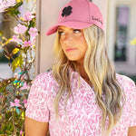 Woman wearing Black Clover Live Lucky premium clover hat in pink and black.