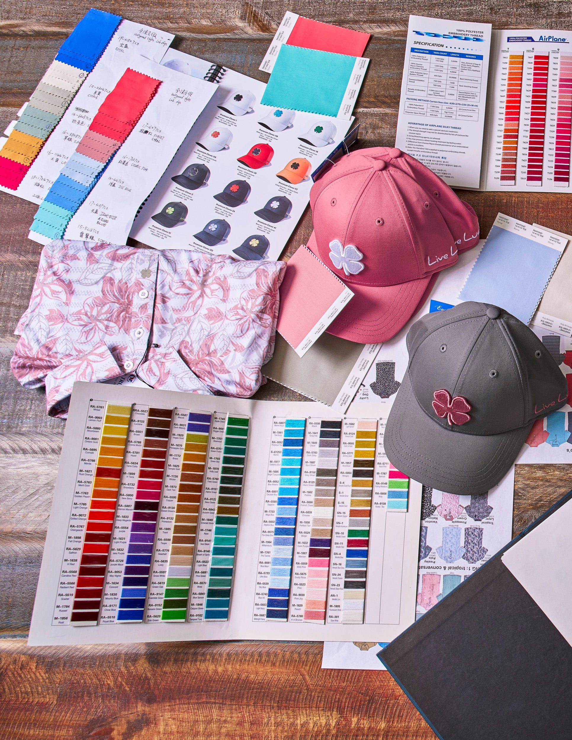A design studio with color swatches and a pink and grey hat on the table.