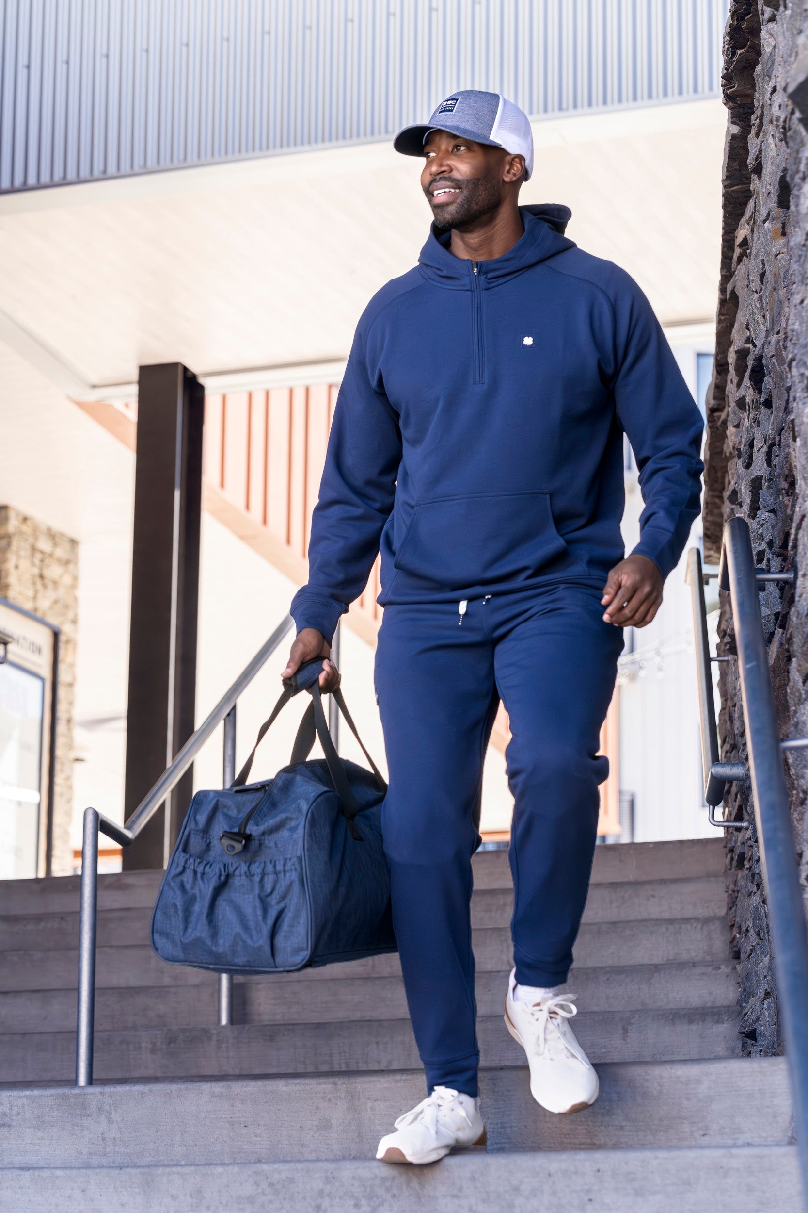 Man wearing Black Clover Live Lucky Cole hat and matching blue sweat suit. 