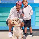 Man wearing Black Clover Live Lucky premium clover hat standing next to his kid and dog.