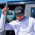 Man standing next to his car wearing a CLVR Black Clover Live Lucky hat in black.