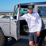 Man standing next to vintage truck wearing Black Clover Live Lucky CLVR hat in black.