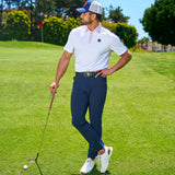 Man standing at golf course wearing blue, red, and white hat from Black Clover Live Lucky.